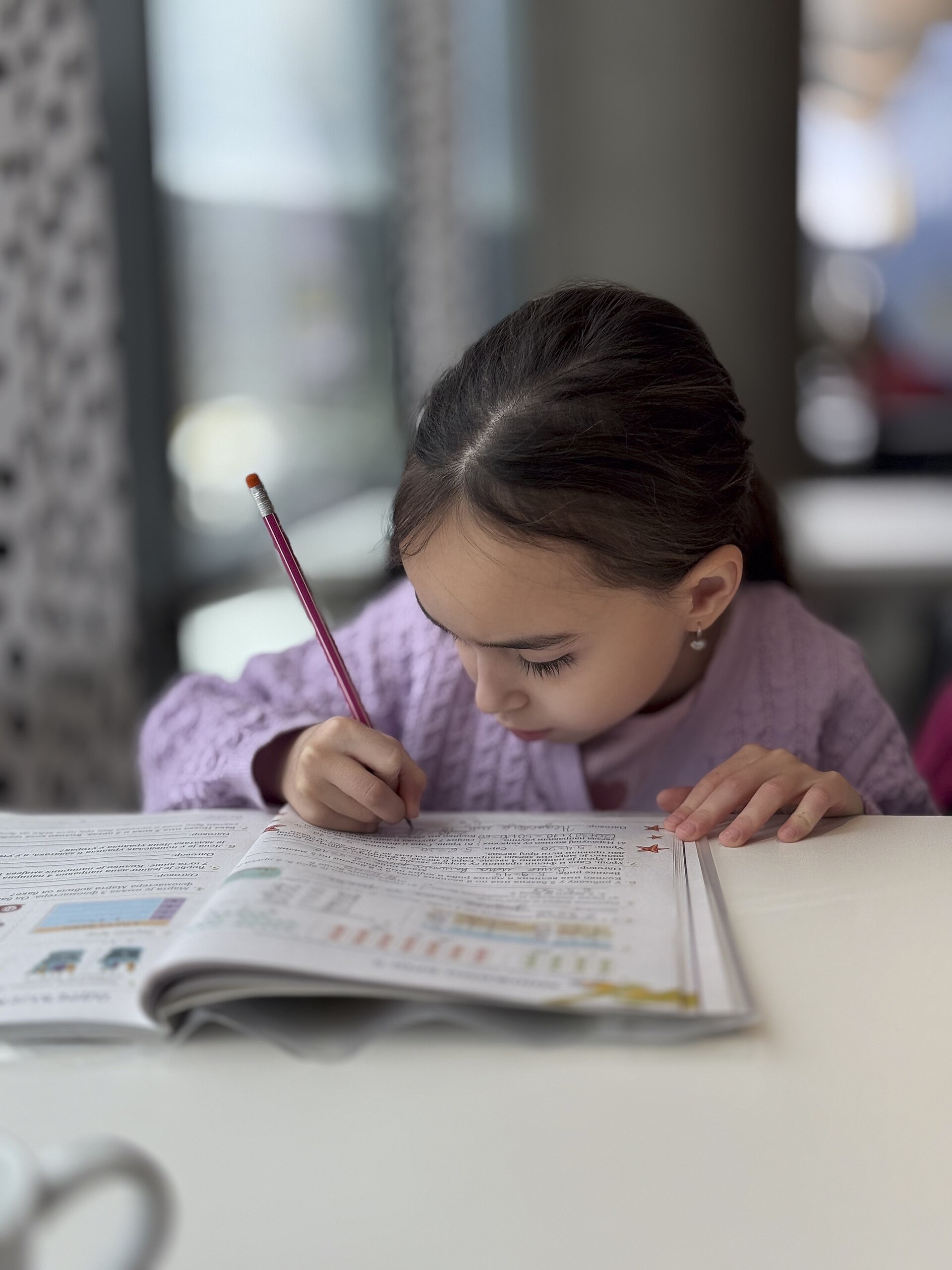 A child writing in a notebook while studying